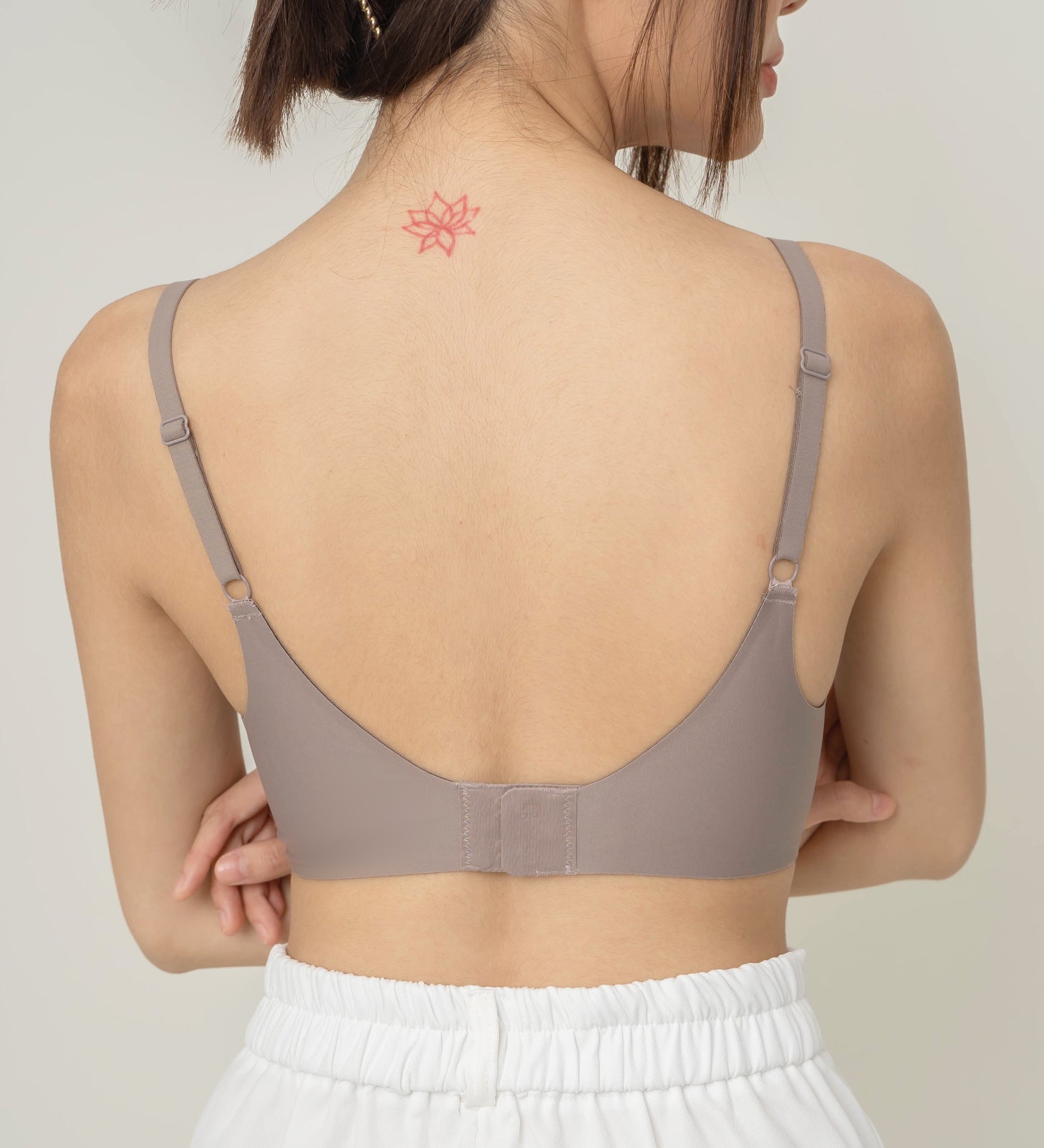 Rear view of Chantelle's Secret Tri-Cup Daily Seamless Bra in taupe, showcasing its sleek design with adjustable straps for a personalized fit.