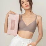 Elegant presentation of Chantelle's Secret Tri-Cup Daily Seamless Bra in a sophisticated taupe, held next to its branded box, ready for the perfect unboxing experience.